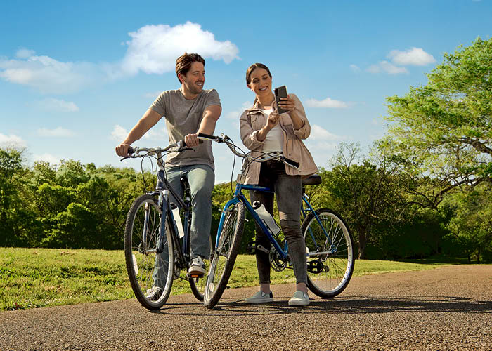 Couple on bikes looking at phone.