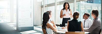 Businesswoman standing and speaking to a small group.