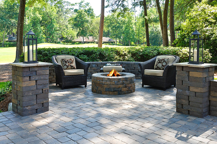Outdoor patio with chairs arranged around a fire pit.