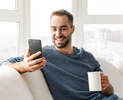 Man on couch looking at phone.