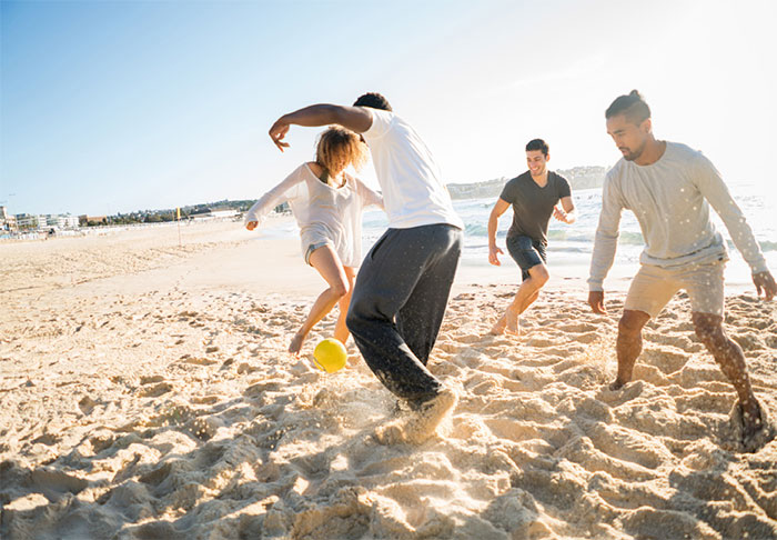 Young adults playing on beach.