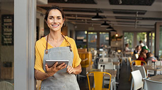 Waitress in a restaurant holding a tablet computer.