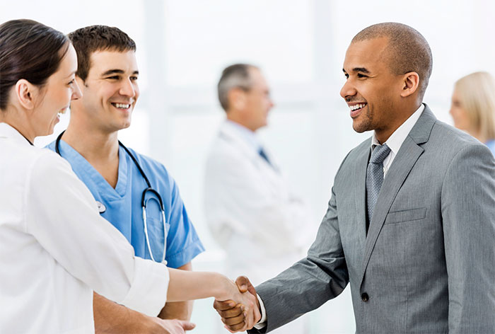 Businessman shaking hands with doctors.